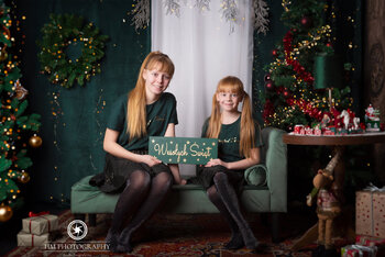 Mama i córka w ciemnozielonych sukienkach przy choince — archiwum HM Photography